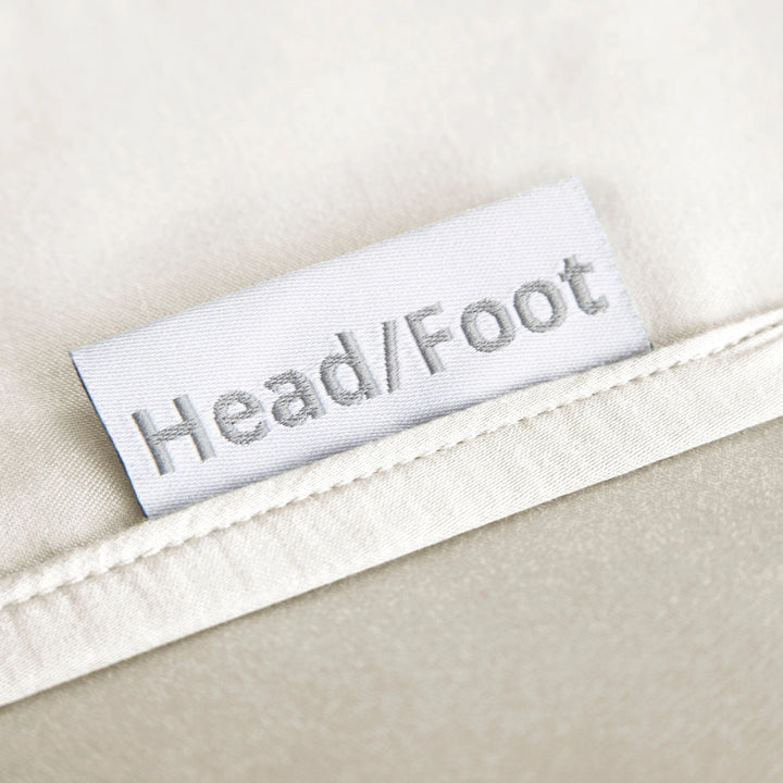 cream bamboo bed sheets with clearly labeled 'head' and 'foot' tags for easy bed-making