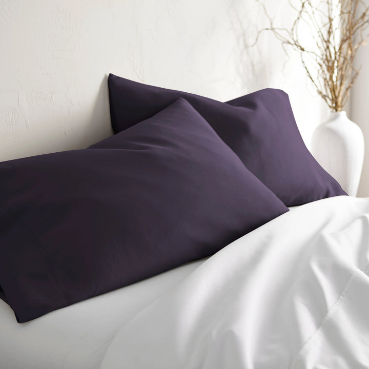royal purple bamboo pillowcases from the Signature Collection, styled on white bedding at an angle with soft natural light