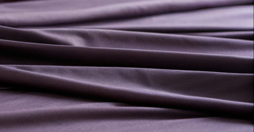Close-up view of luxurious royal purple fabric texture, highlighting fine details and rich color for high-quality textile products.