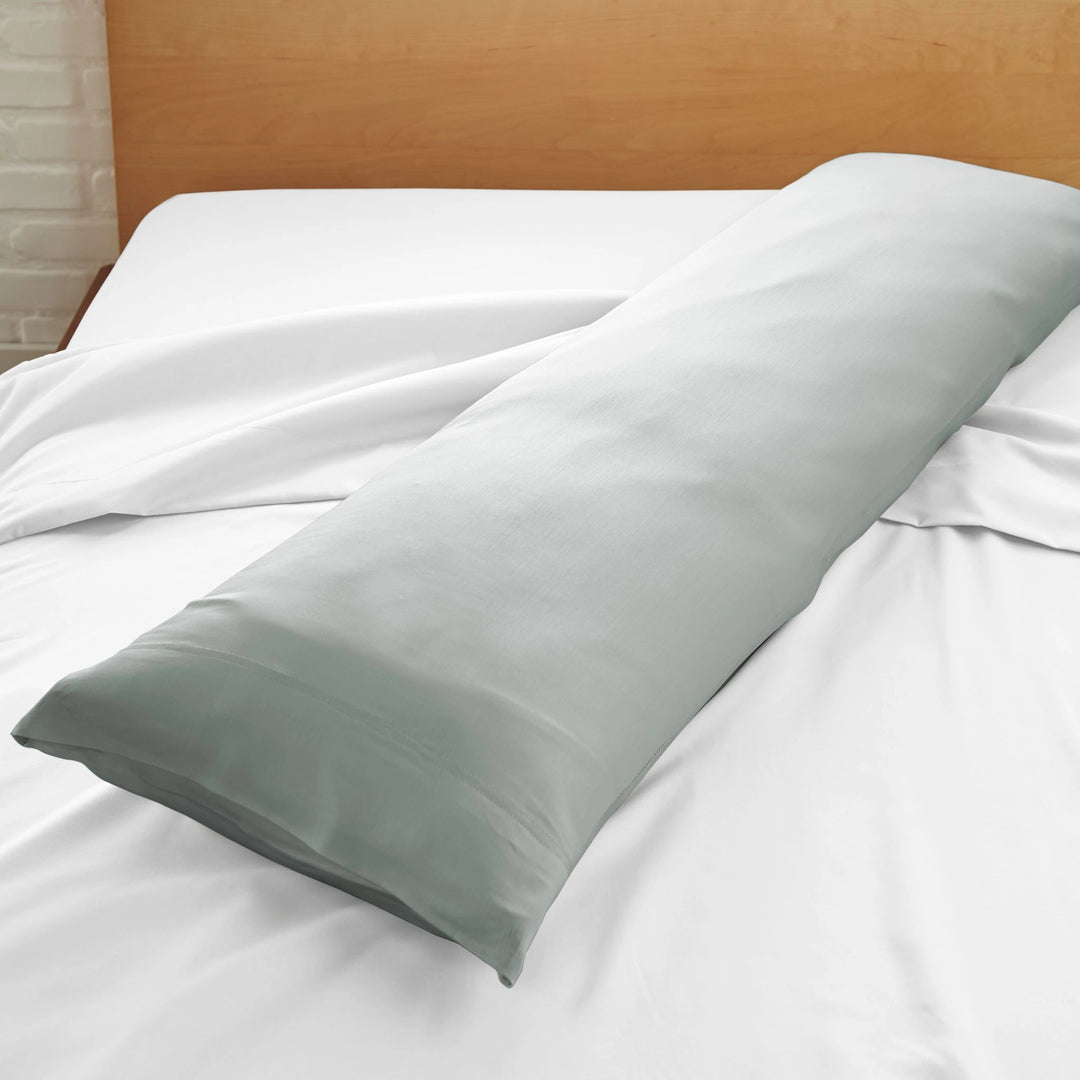 silver bamboo body pillow with sateen weave from the Signature Collection, displayed on a white bed for contrast and texture focus