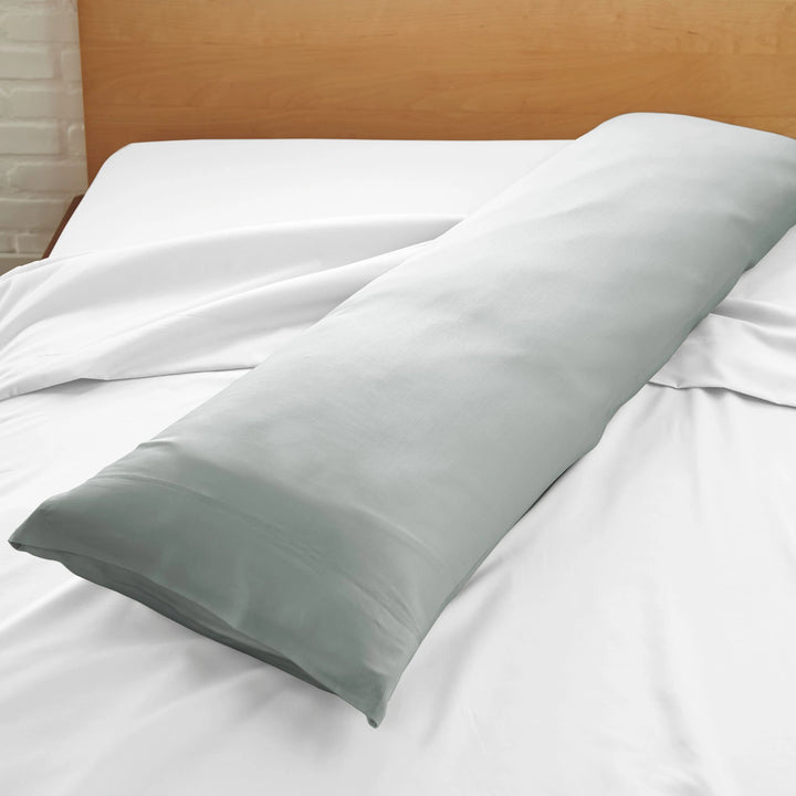 silver bamboo body pillow with sateen weave from the Signature Collection, displayed on a white bed for contrast and texture focus