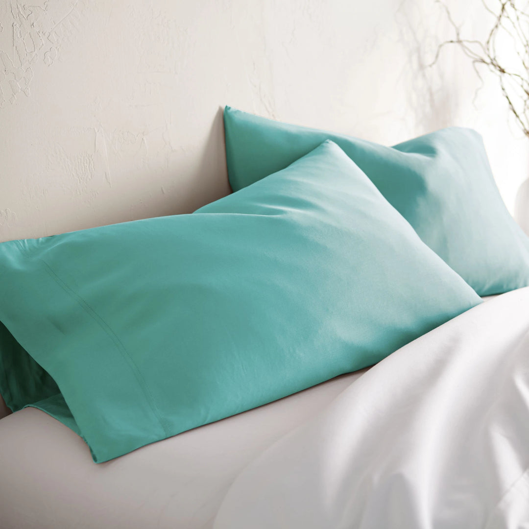 tiffany blue bamboo pillowcases from the Signature Collection, styled on tiffany blue bedding at an angle with soft natural light