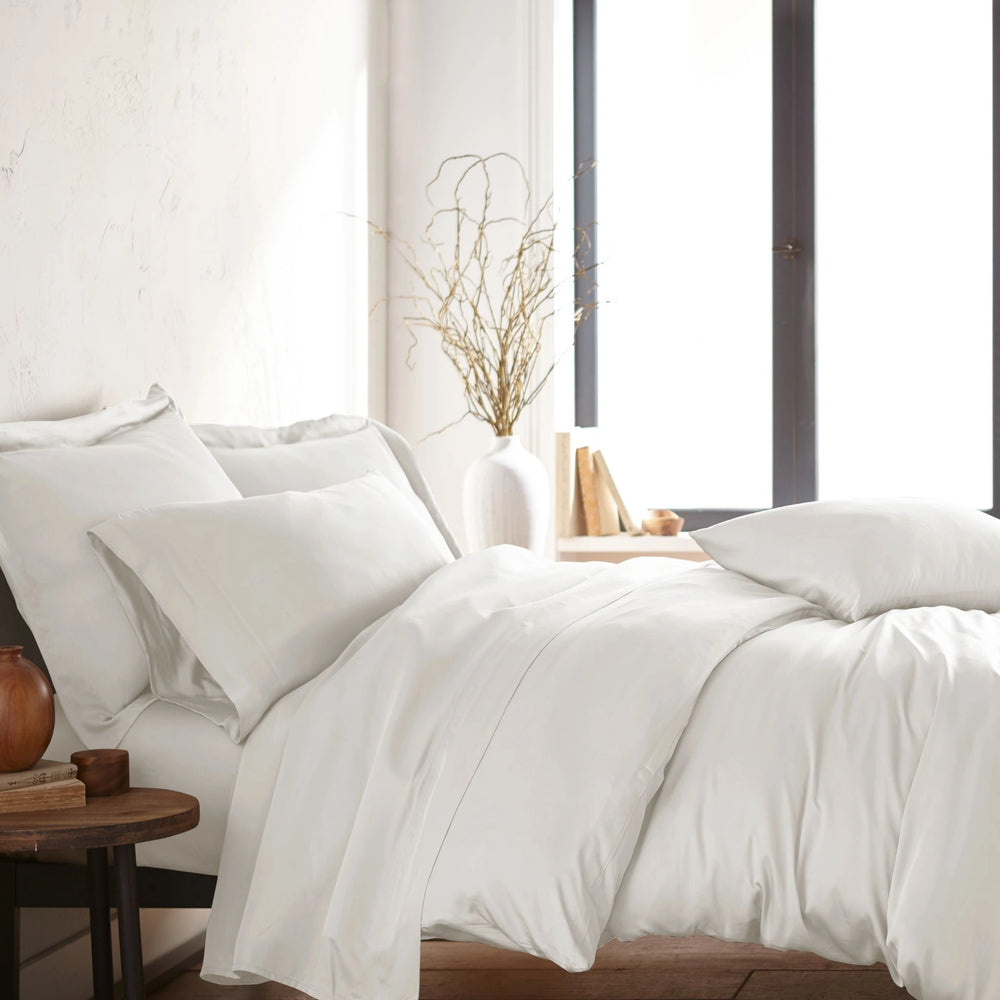 modern bedroom with white bamboo sateen sheet set on king bed, featuring matching pillowcases and duvet, styled with natural light and minimal decor