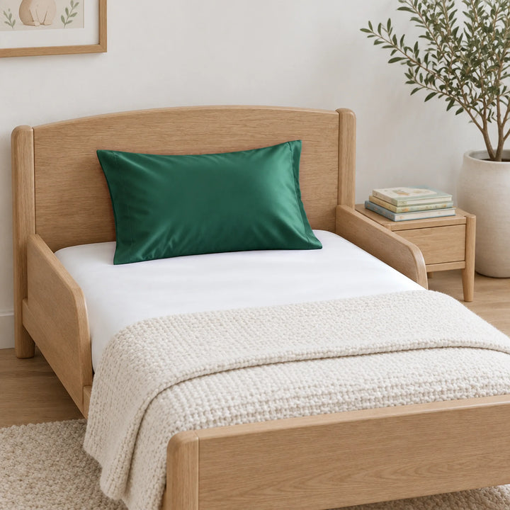 Emerald green cooling bamboo viscose toddler pillowcase on a light-oak toddler bed