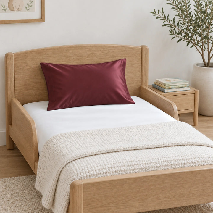 Ruby red cooling bamboo viscose toddler pillowcase on a light-oak toddler bed
