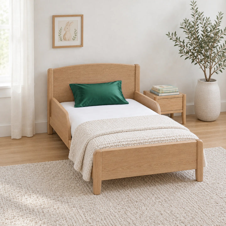 Emerald green cooling bamboo viscose toddler pillowcase on a toddler bed in a calm, light nursery
