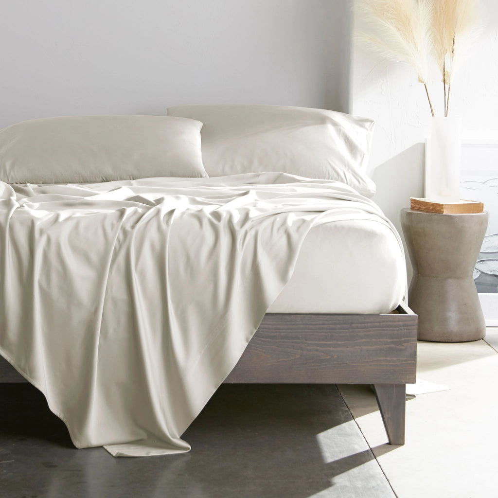 Cream bamboo bed sheets with sateen weave from the Premium Collection, shown from the foot of the bed with a draped flat sheet and matching pillowcases