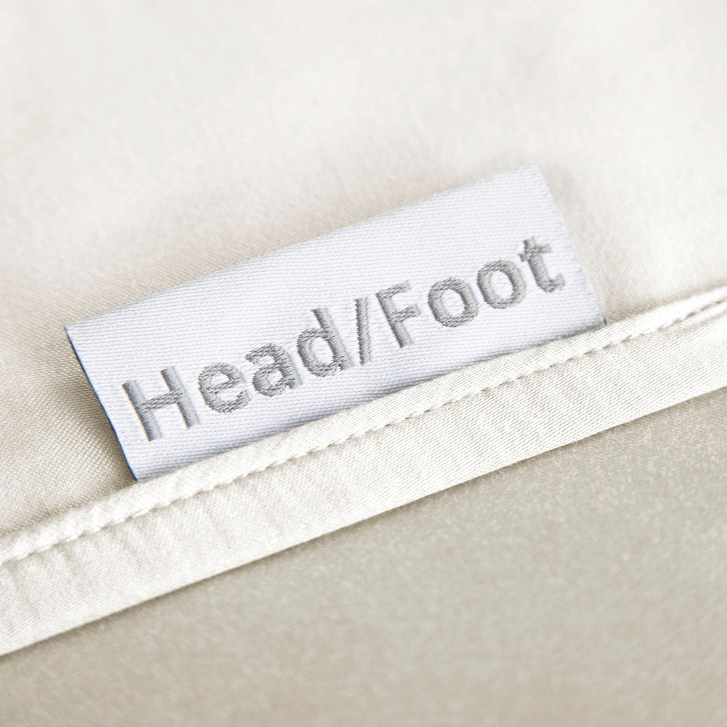 cream bamboo bed sheets with clearly labeled 'head' and 'foot' tags for easy bed-making