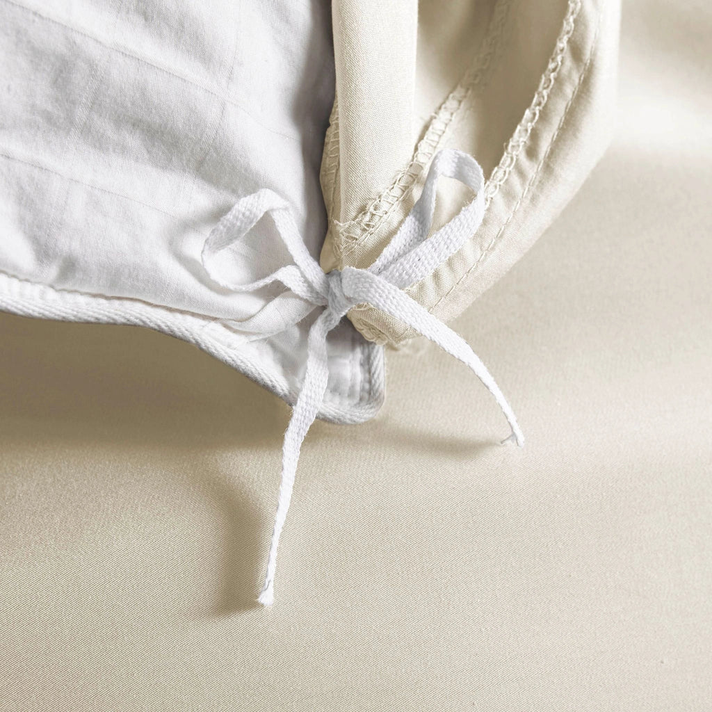 Cream bamboo duvet cover from the Premium Collection, close-up of internal corner tie securing white insert with smooth sateen fabric