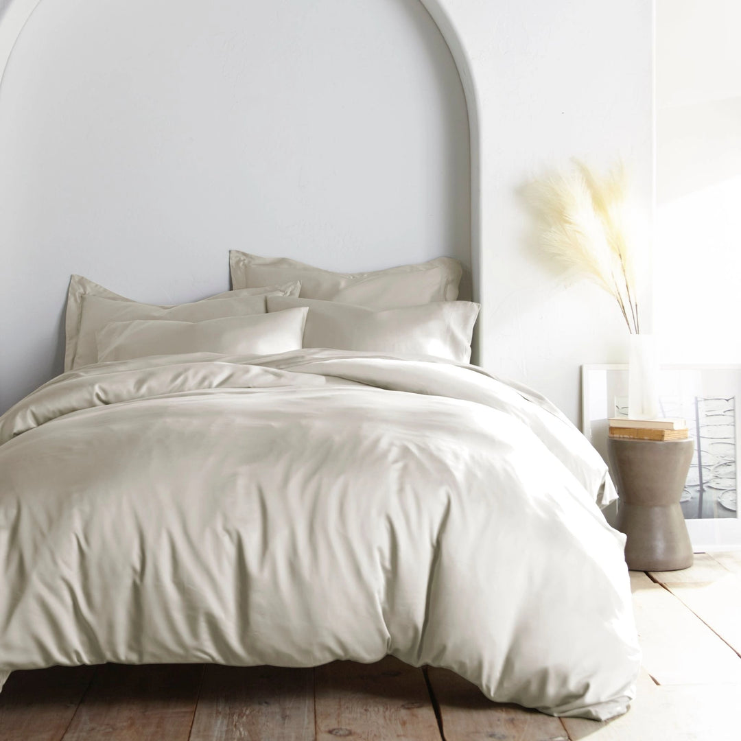 Cream bamboo bed sheets with sateen weave from the Premium Collection, shown foot view with matching pillowcases and a modern nightstand