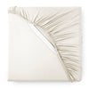 Cream bamboo sateen fitted sheet corner with white elastic strap, showing snug fit and smooth fabric texture