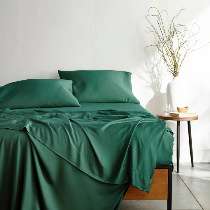 Emerald green bamboo bed sheet set from the 100% Bamboo Collection on a modern wooden bed, featuring ultra-soft, eco-friendly, and temperature-regulating sheets and pillowcases, styled with minimalist decor and natural lighting.