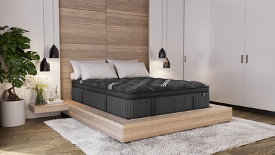 Graphene Cool 2.0 Hybrid Mattress displayed in a modern bedroom with a wooden platform bed, white bedding, pendant lights, and plants for a calming, luxurious look.