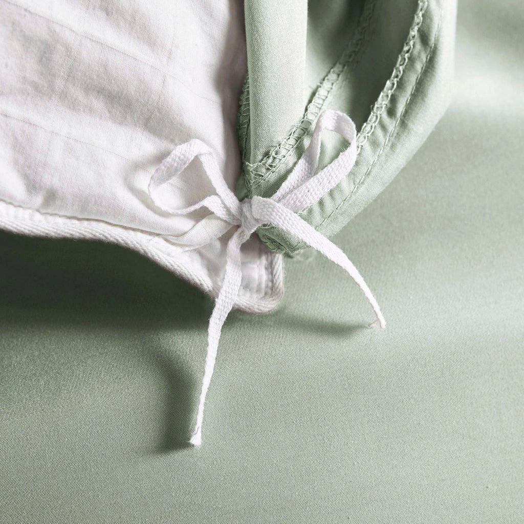 Sage bamboo bed sheets with sateen weave from the Premium Collection, shown foot view with matching pillowcases and a modern nightstand