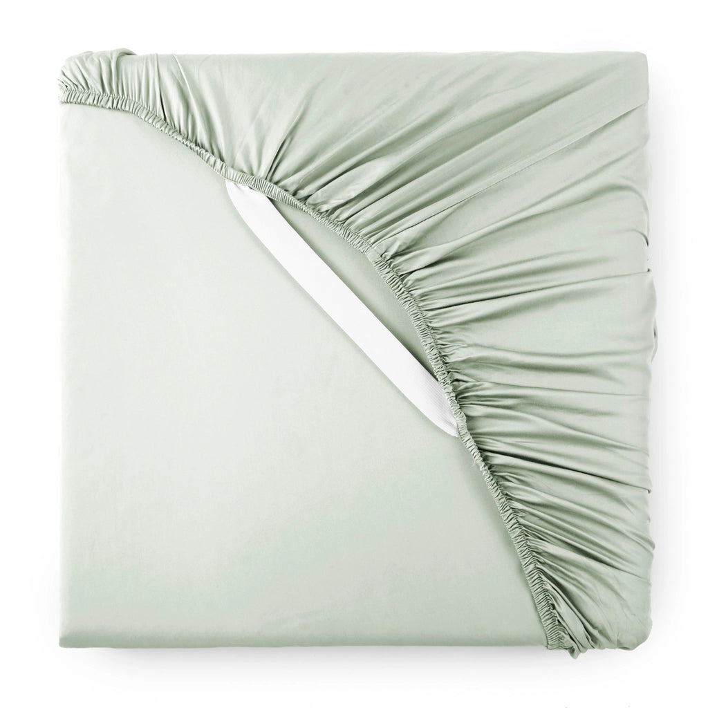 Sage bamboo sateen fitted sheet corner with white elastic strap, showing snug fit and smooth fabric texture