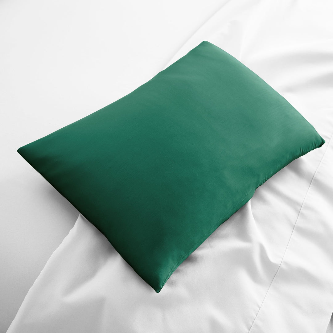 emerald green bamboo lumbar pillowcase from the Signature Collection, displayed flat on white bedding with sateen finish and soft texture