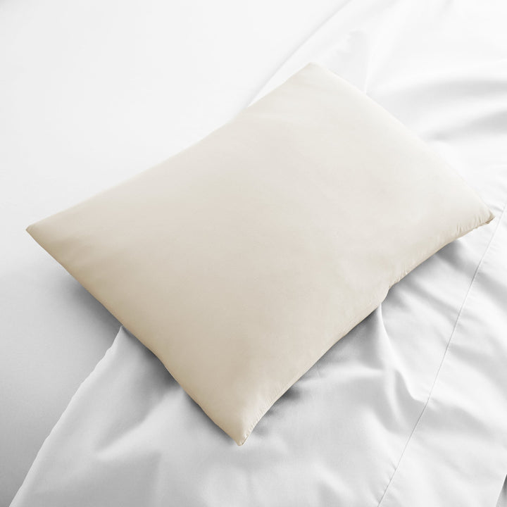 ivory bamboo lumbar pillowcase from the Signature Collection, displayed flat on white bedding with sateen finish and soft texture