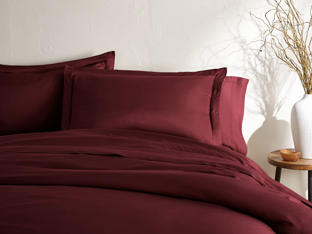 ruby red bamboo duvet cover and matching shams from the Signature Collection, styled on a made king bed