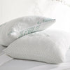Two adjustable bamboo cooling pillows with zippered covers on a white bed – breathable, washable, and eco-friendly design for hot sleepers.