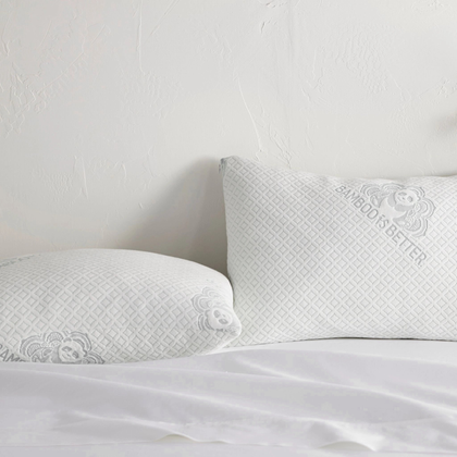 Pair of adjustable cooling bamboo pillows on a neatly made white bed.