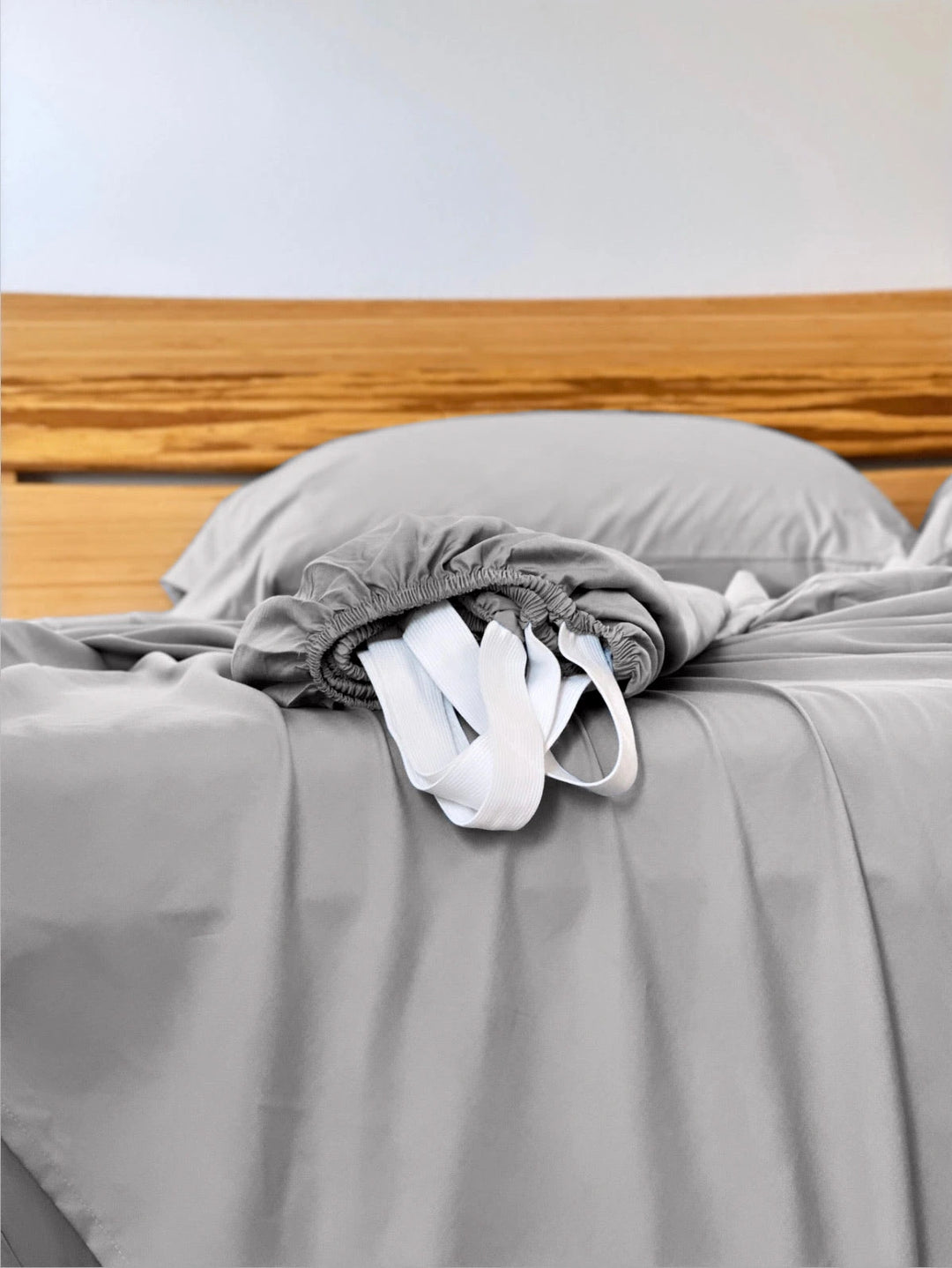 Feather Gray copper-infused bamboo fitted sheet — corner detail showing the elastic hem and reinforced corner straps for a secure fit.