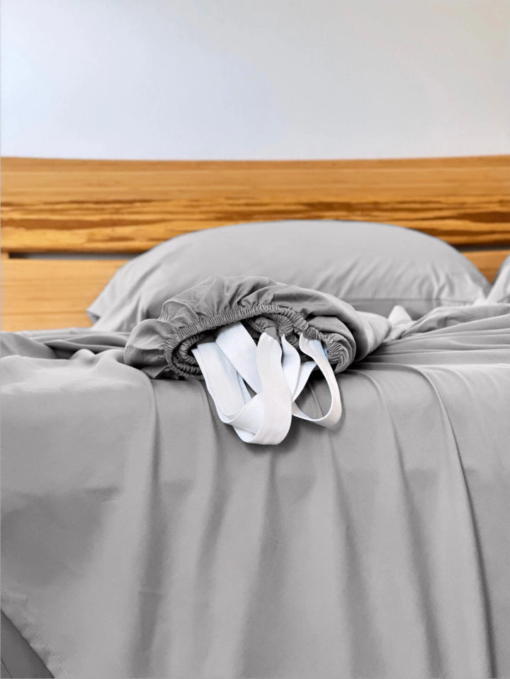 Feather Gray copper-infused bamboo fitted sheet — corner detail showing the elastic hem and reinforced corner straps for a secure fit.