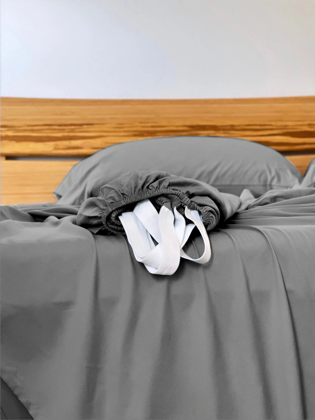 Graphite Gray copper-infused bamboo fitted sheet — corner detail showing the elastic hem and reinforced corner straps for a secure fit.