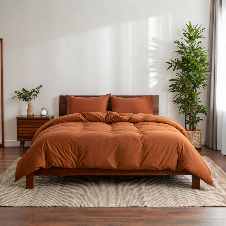 Rust copper-infused bamboo viscose duvet cover on a walnut bed in a sunlit bedroom — smooth, breathable sateen weave.