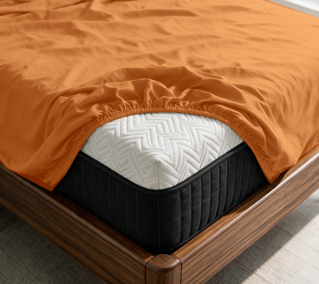 Rust copper-infused bamboo fitted sheet on a mattress in a sunlit walnut bedroom — breathable, cooling sateen weave.