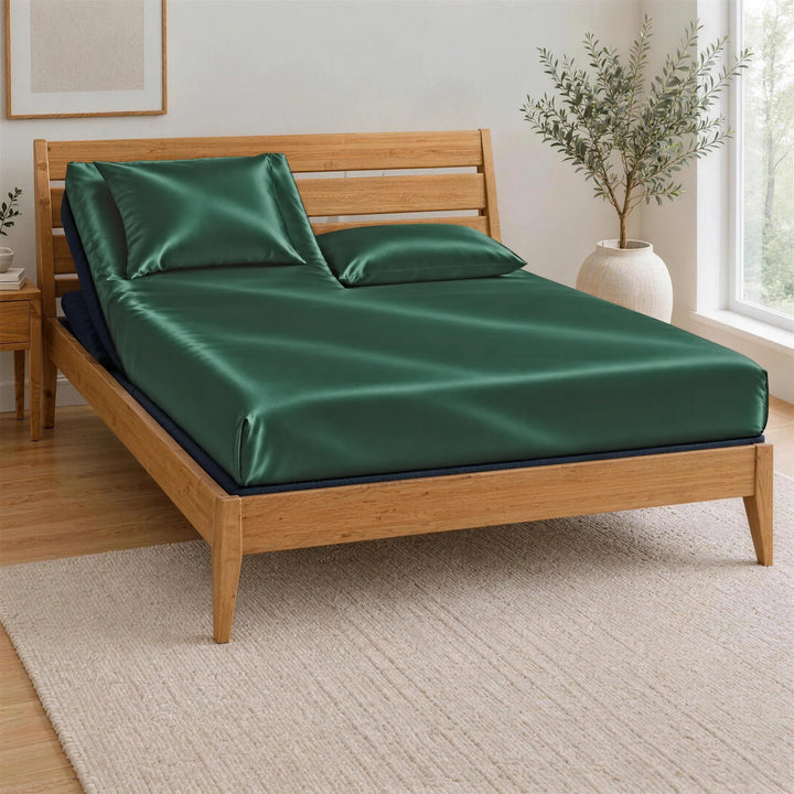 Emerald Green bamboo viscose Signature fitted sheet on a Top Split King bed: one mattress split at the head only, on an adjustable base in a bamboo frame, left head section raised