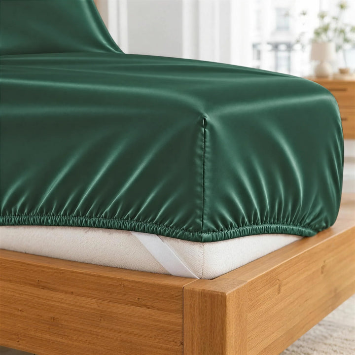 Emerald Green bamboo viscose fitted sheet deep-pocket corner close-up with all-around elastic and a corner strap, from the sheet set