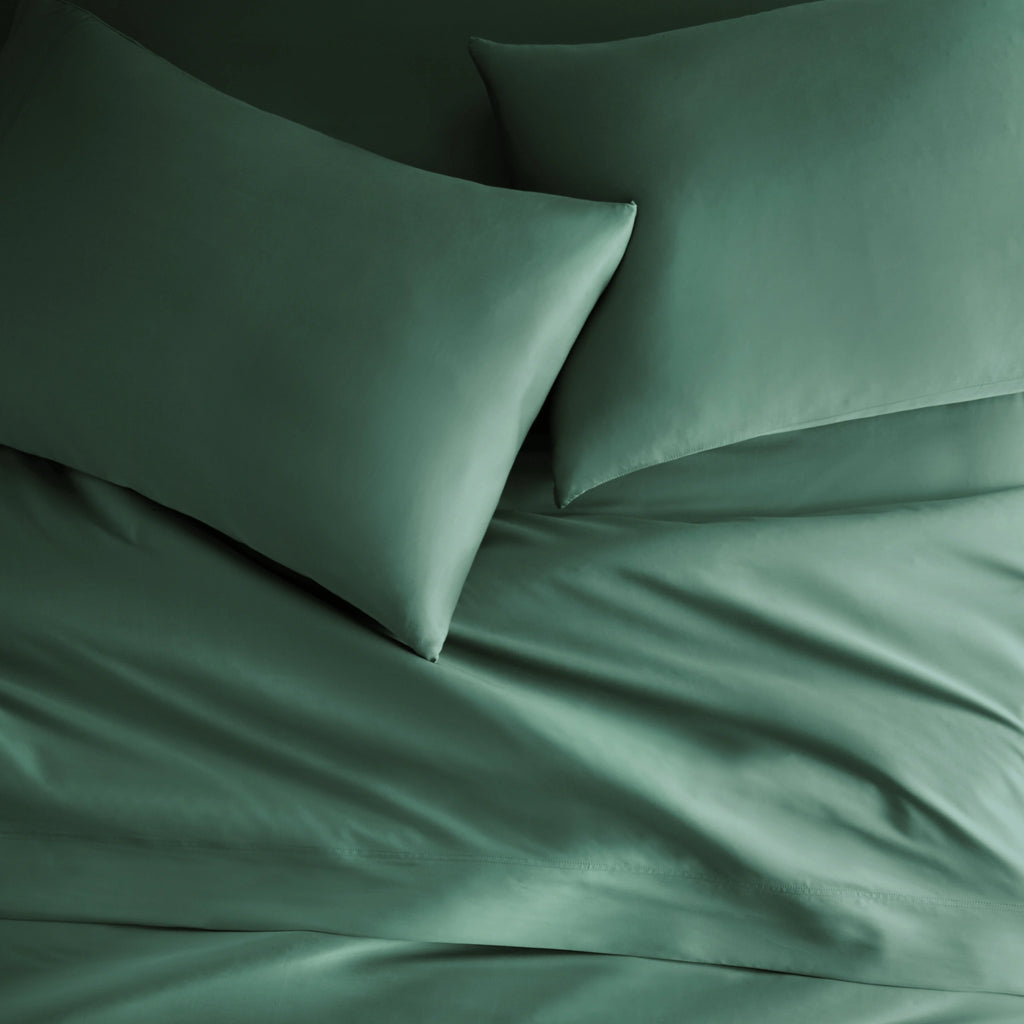 emerald green bamboo bed sheets with sateen weave from the Signature Collection, overhead view highlighting smooth texture and matching pillowcases