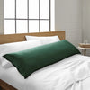 emerald green bamboo body pillow from the Signature Collection, shown on a emerald green bed in a bright modern bedroom with natural light and wood headboard