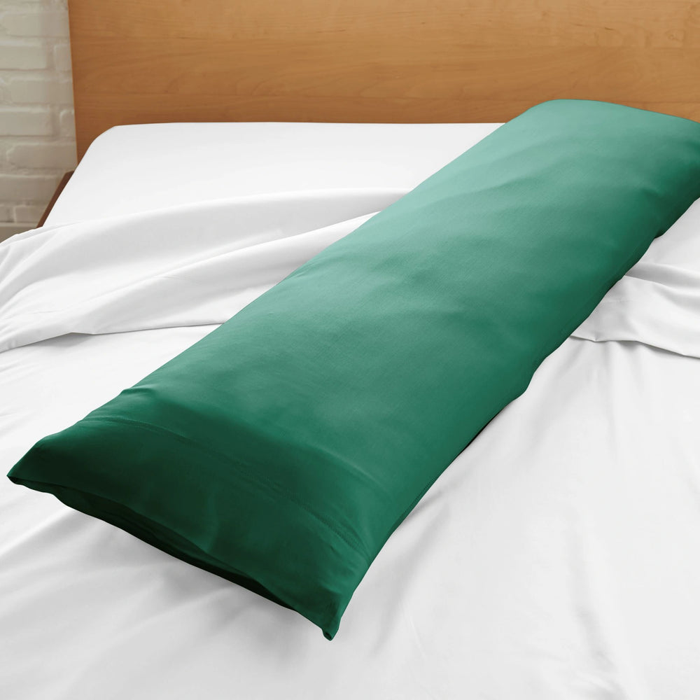 emerald green bamboo body pillow with sateen weave from the Signature Collection, displayed on a emerald green bed for contrast and texture focus