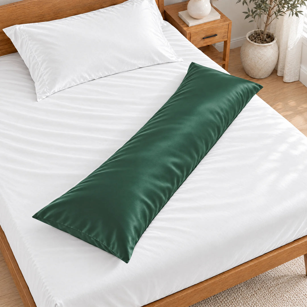 Emerald Green bamboo viscose sateen body pillowcase lying diagonally across a made bed, overhead view in a bright bedroom with a honey bamboo bed