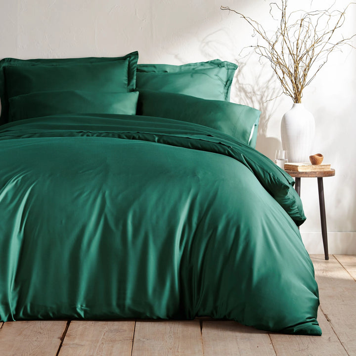 emerald green bamboo bed sheets with sateen weave from the Signature Collection, shown foot view with matching pillowcases and a modern nightstand