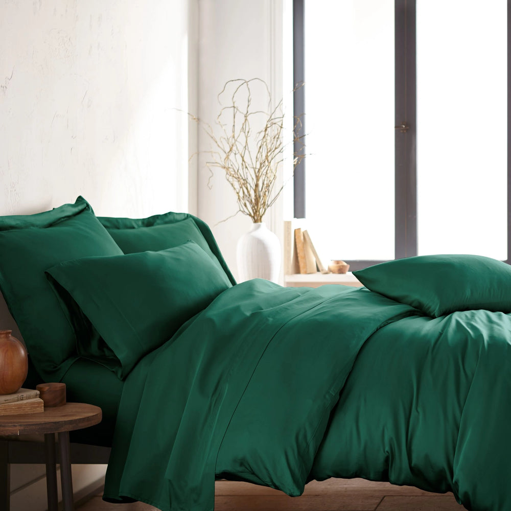 modern bedroom with emerald green bamboo sateen sheet set on king bed, featuring matching pillowcases and duvet, styled with natural light and minimal decor
