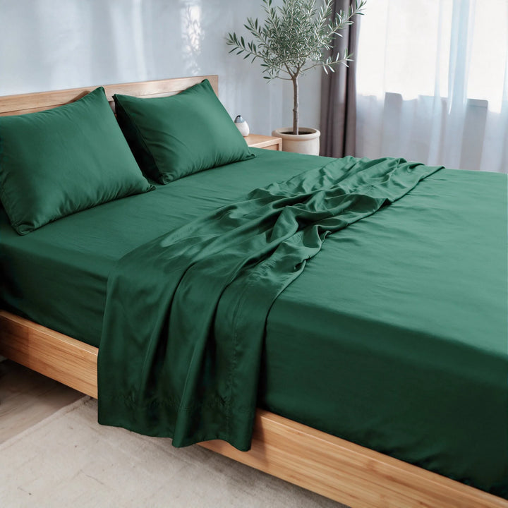 emerald green bamboo viscose sateen sheet set, three-quarter view with the flat sheet pulled back over the fitted sheet