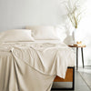 ivory bamboo bed sheets with sateen weave from the Signature Collection, shown from the foot of the bed with a draped flat sheet and matching pillowcases