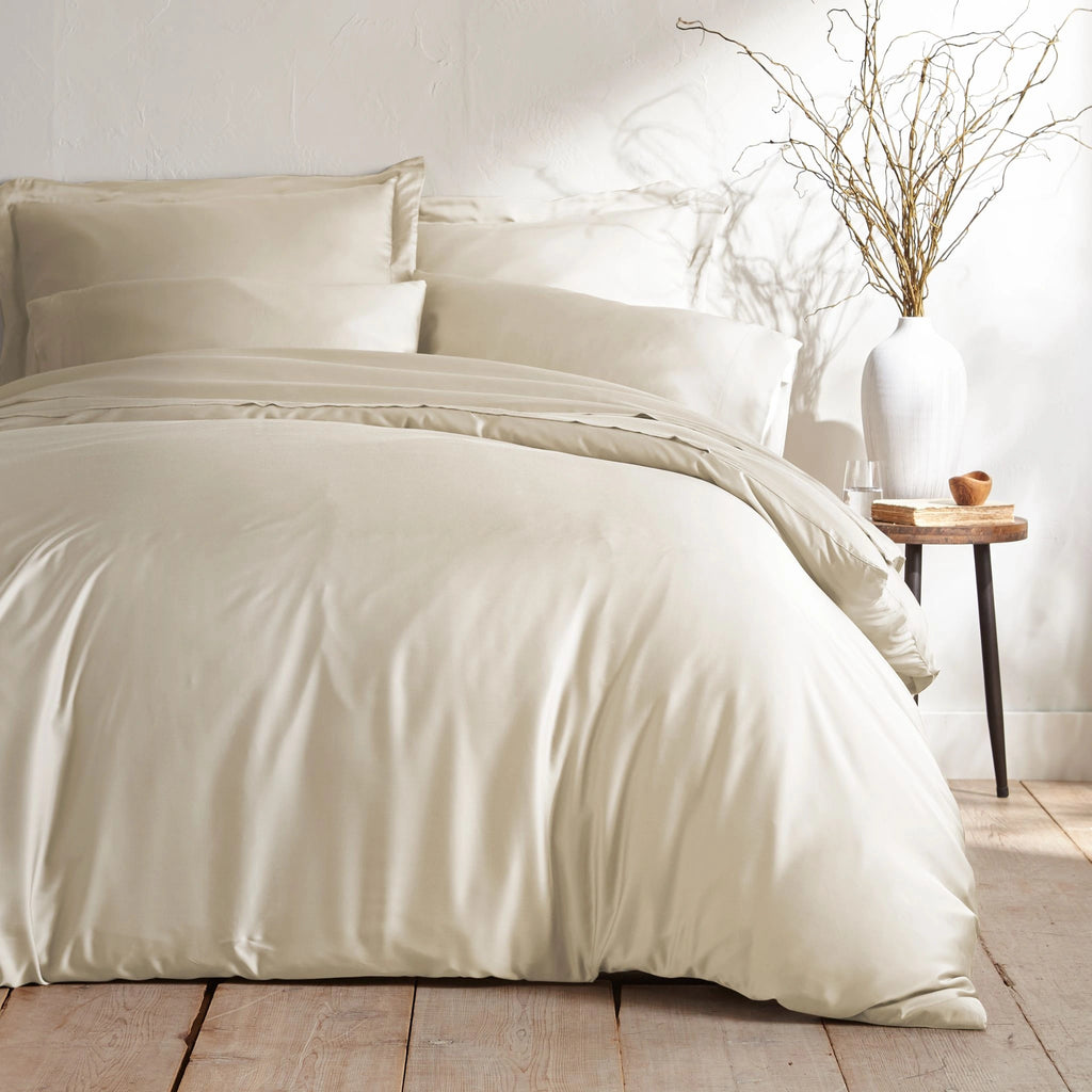 ivory bamboo bed sheets with sateen weave from the Signature Collection, shown foot view with matching pillowcases and a modern nightstand