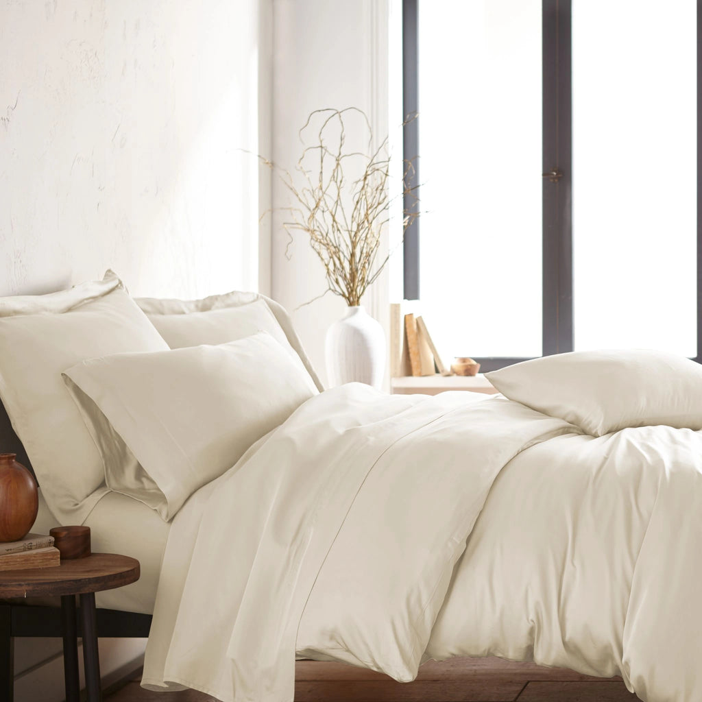 modern bedroom with ivory bamboo sateen sheet set on king bed, featuring matching pillowcases and duvet, styled with natural light and minimal decor