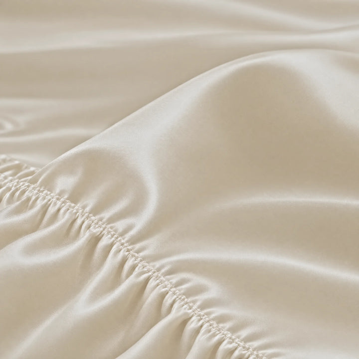 Ivory bamboo viscose Signature fitted sheet macro close-up of smooth silky sateen folds and a stitched elastic hem