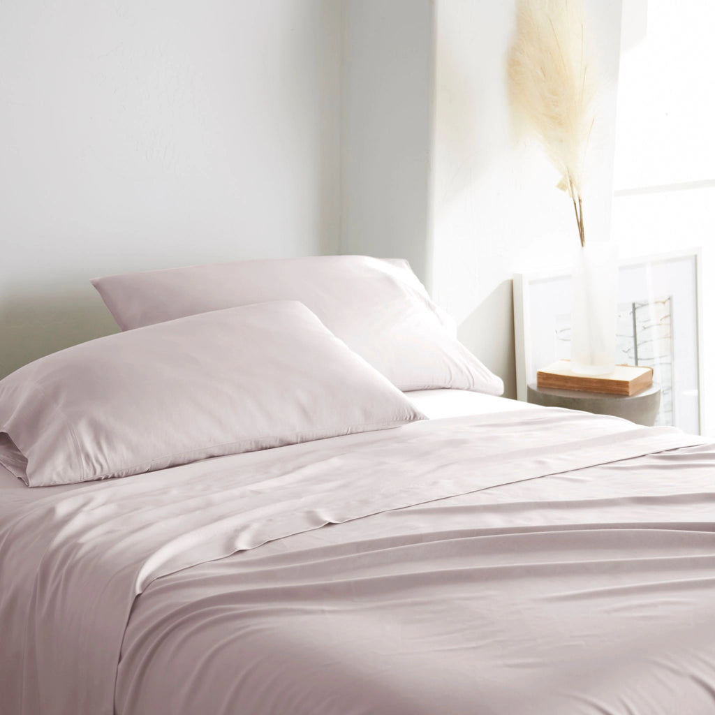 mauve bamboo bed sheets with sateen weave from the Premium Collection, three-quarter angle showing natural folds and soft lighting from nearby window