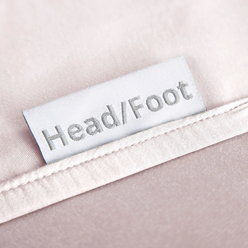 Mauve bamboo bed sheets with clearly labeled 'head' and 'foot' tags for easy bed-making