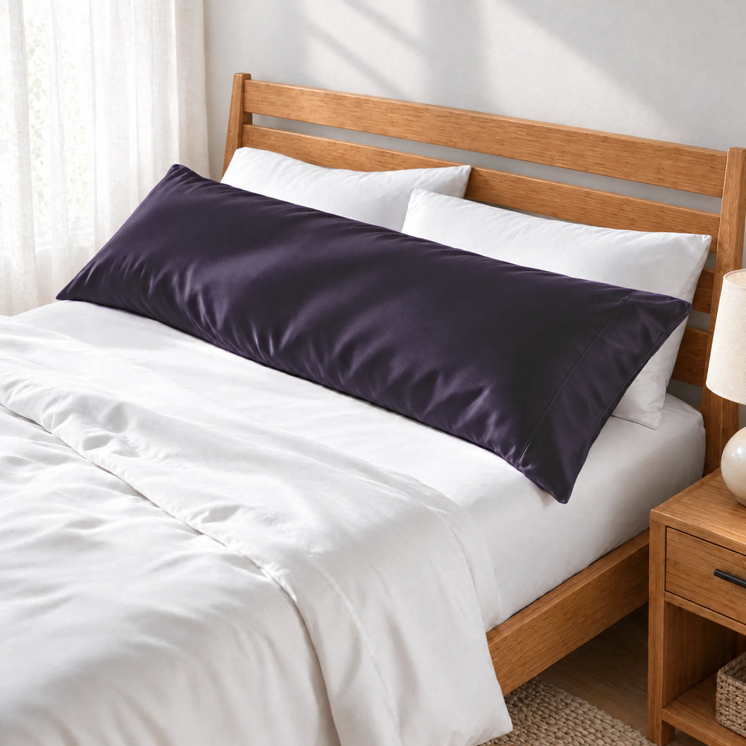 Royal Purple bamboo viscose sateen body pillowcase along the headboard of a made bed, three-quarter view from the foot of the bed