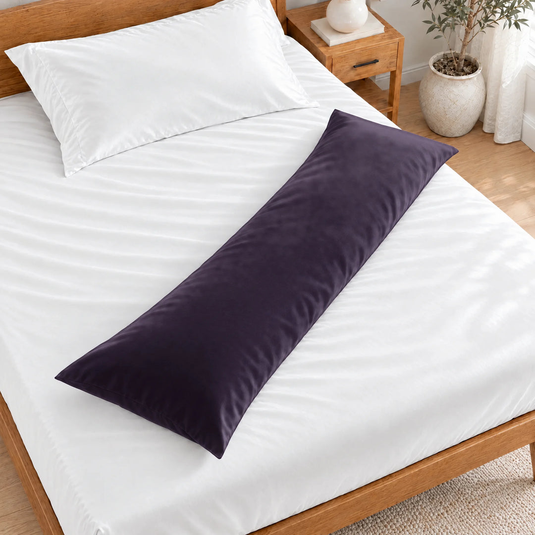 Royal Purple bamboo viscose sateen body pillowcase lying diagonally across a made bed, overhead view in a bright bedroom with a honey bamboo bed