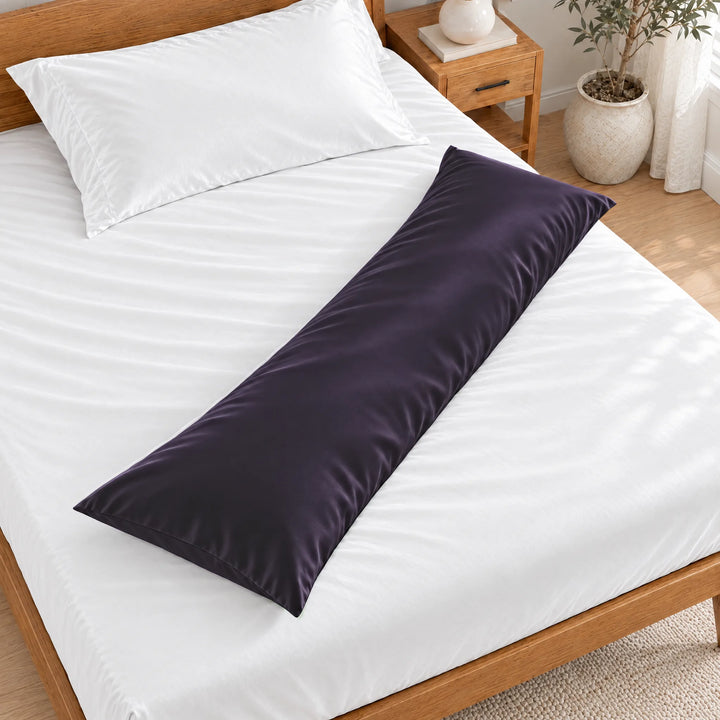 Royal Purple bamboo viscose sateen body pillowcase lying diagonally across a made bed, overhead view in a bright bedroom with a honey bamboo bed