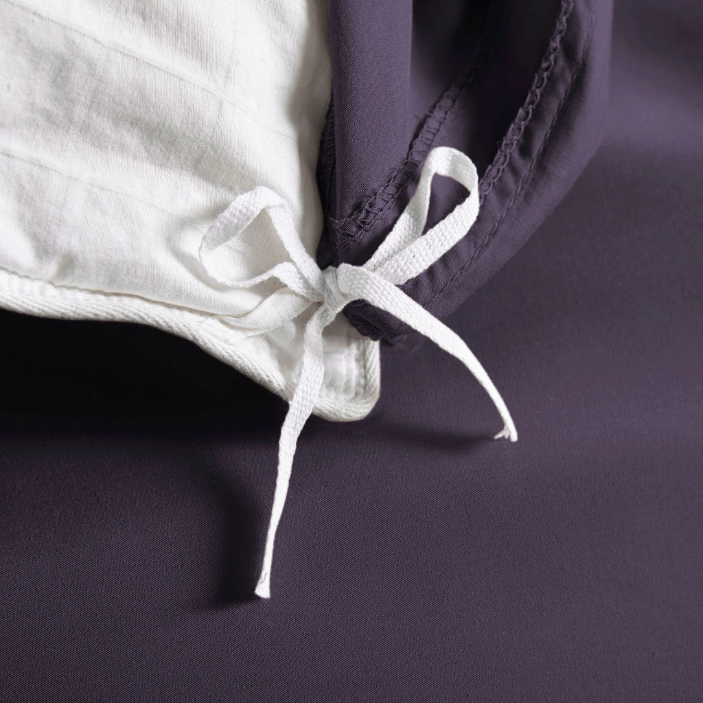 royal purple bamboo duvet cover from the Signature Collection, close-up of internal corner tie securing white insert with smooth sateen fabric