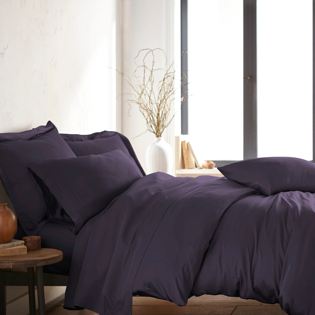 modern bedroom with royal purple bamboo sateen sheet set on king bed, featuring matching pillowcases and duvet, styled with natural light and minimal decor