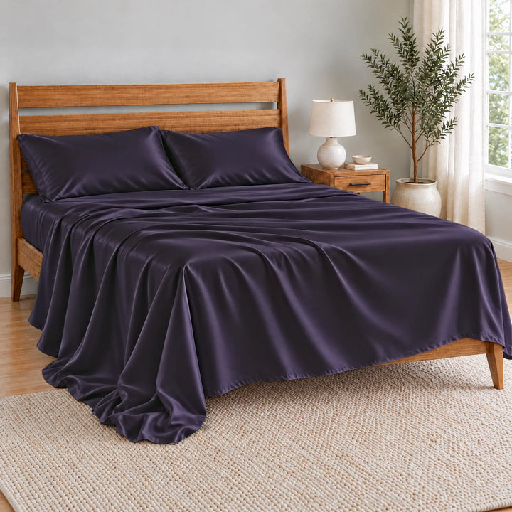 Royal Purple bamboo viscose flat sheet oversized and relaxed, spilling over the side of the bed in soft folds